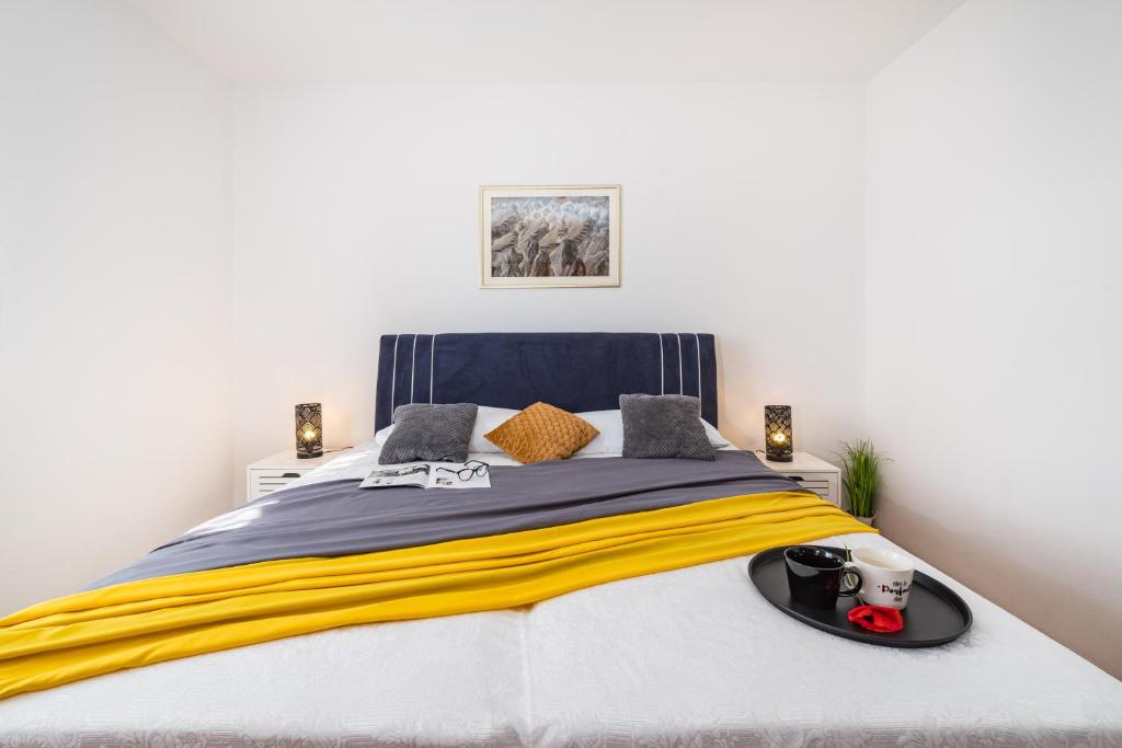- une chambre avec un lit doté d'une couverture jaune et bleue dans l'établissement Apartment Marija, à Novigrad
