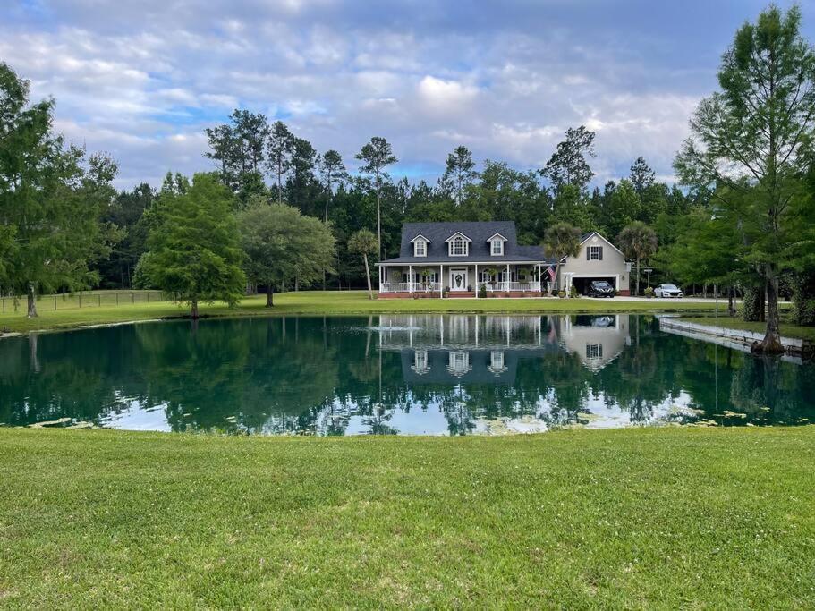 a house with a large pond in front of it at Country Villa pool hot tub game room pond in Jacksonville