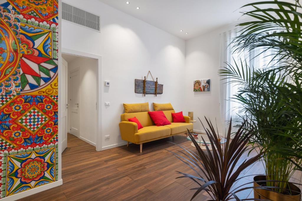 ein Wohnzimmer mit einem gelben Sofa und roten Kissen in der Unterkunft Casa Brezi in Palermo