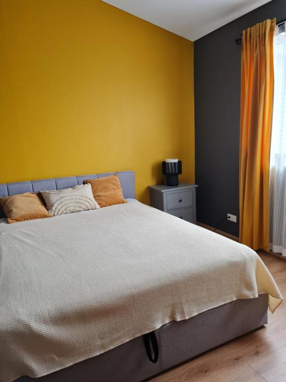sypialnia z łóżkiem i żółtą ścianą w obiekcie FLOWER HOUSE w mieście Hvolsvöllur