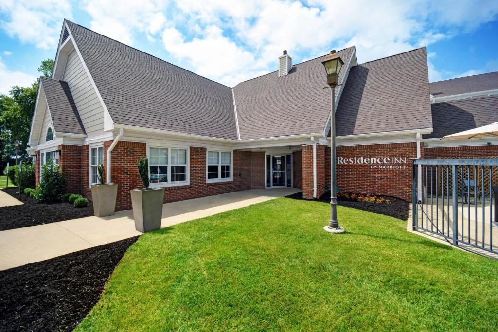 une maison avec une lumière de rue dans l'herbe dans l'établissement Residence Inn Louisville Airport, à Louisville