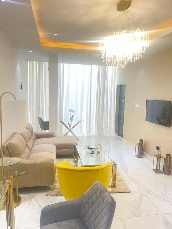 a living room with a couch and a chandelier at Gold Flat in Accra