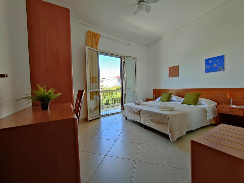 a hotel room with a bed and a balcony at Appartamenti in Villa Polimnia in Fontane Bianche