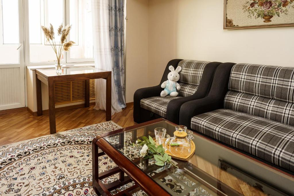 uma sala de estar com um sofá e um ursinho de peluche em Золотой квадрат 60 кв2 em Almaty