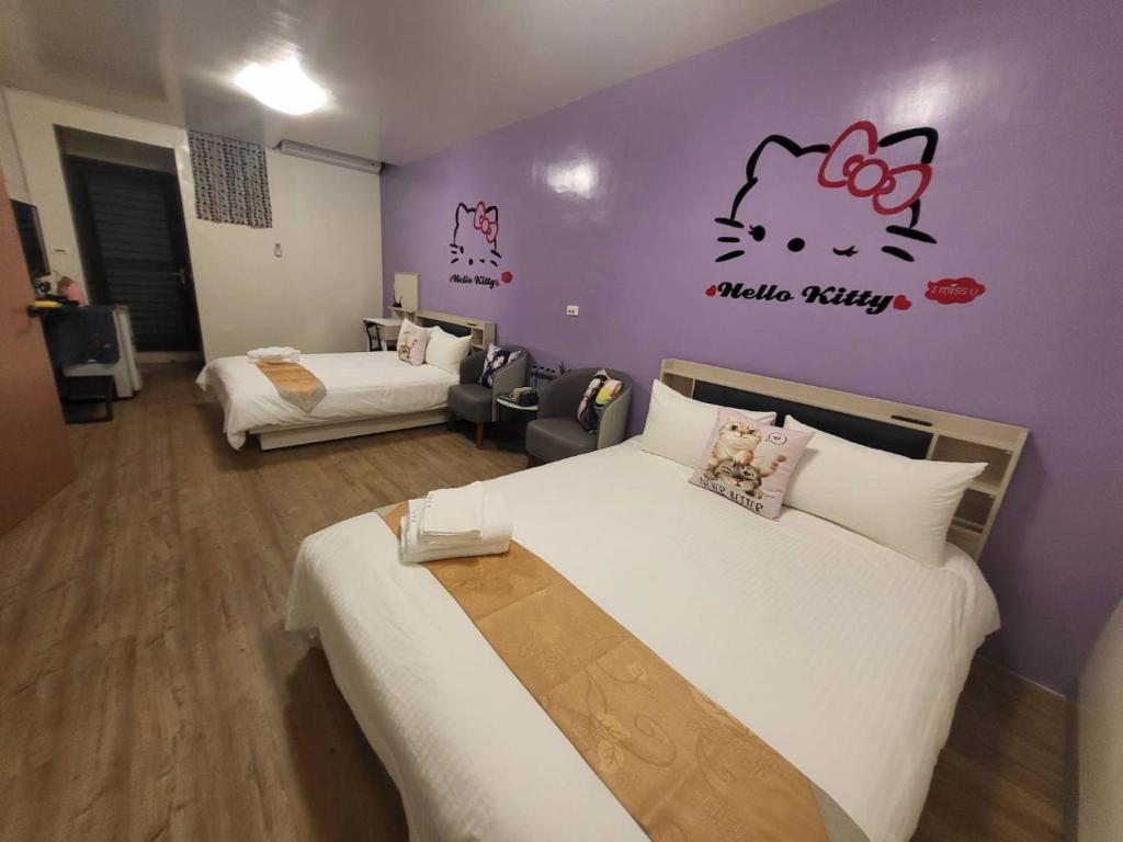 - une chambre avec 2 lits et un mur violet dans l'établissement Wanghong Homestay, à Hengchun Old Town