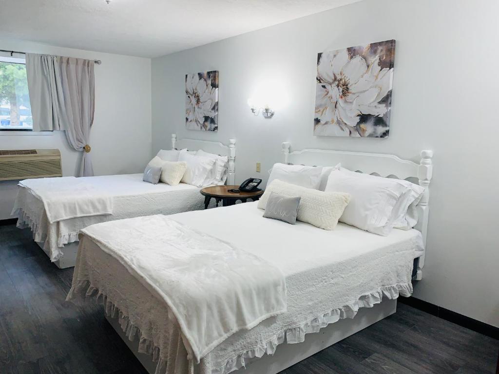 - une chambre blanche avec 2 lits et des draps blancs dans l'établissement EC Reed's Mercantile and Hotel, à Marble Hill