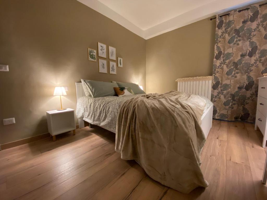 1 dormitorio con 1 cama y 1 lámpara en el suelo de madera en Casa di Lucy Umbria, en Foligno
