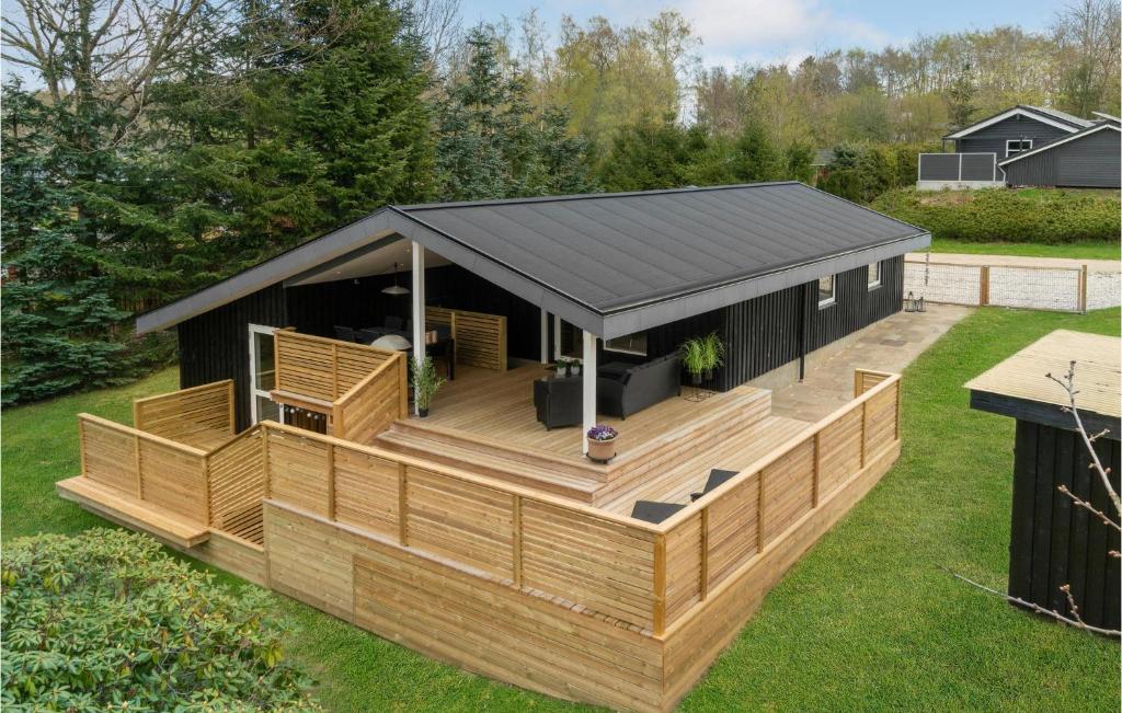 a house with a large deck and a black roof at Cozy Home In Fårvang With Wifi in Fårvang