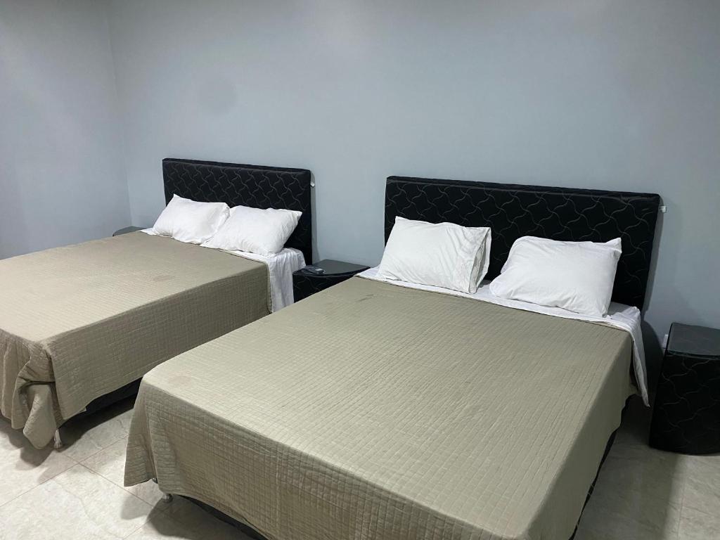 two beds sitting next to each other in a room at España Suites Hotel in Ciudad del Este