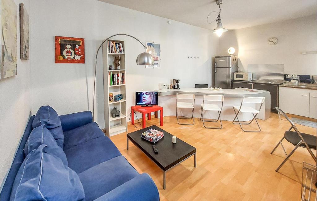 salon z niebieską kanapą i stołem w obiekcie 1 Bedroom Lovely Apartment In Saint-etienne w mieście Saint-Étienne