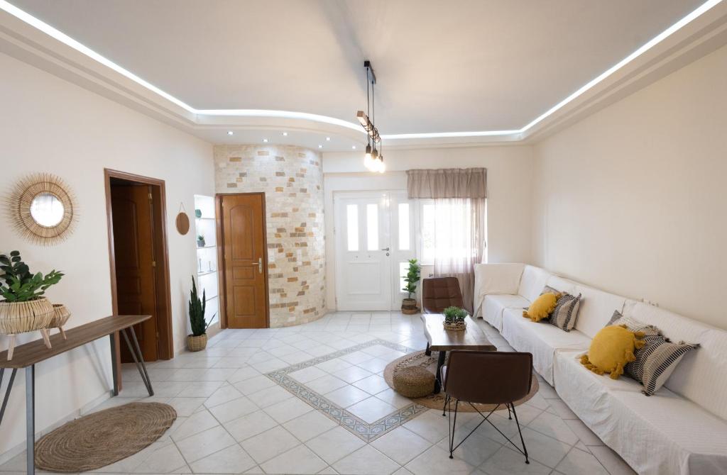 salon z białą kanapą i stołem w obiekcie CITY CENTER VILLA HERSONISOS w mieście Hersonissos