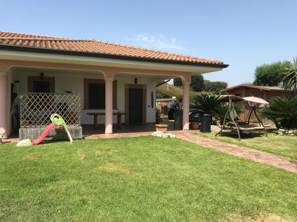 a house with a green yard with a playground at Villa Circe in San Felice Circeo