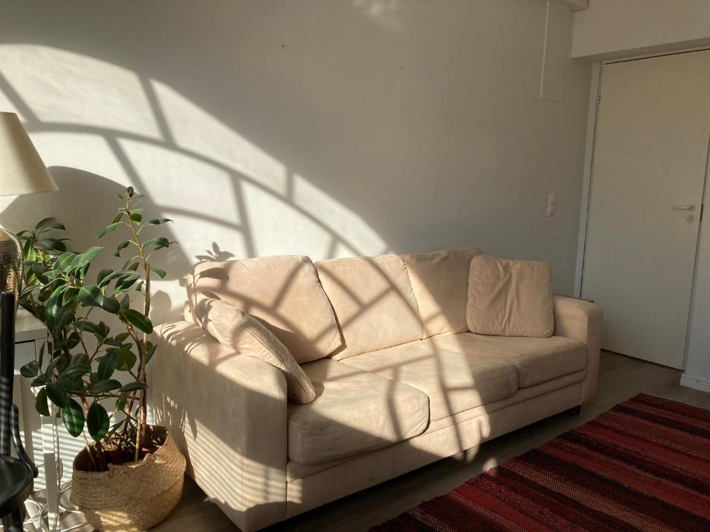 a living room with a white couch in front of a wall at Corner apartment in Helsinki