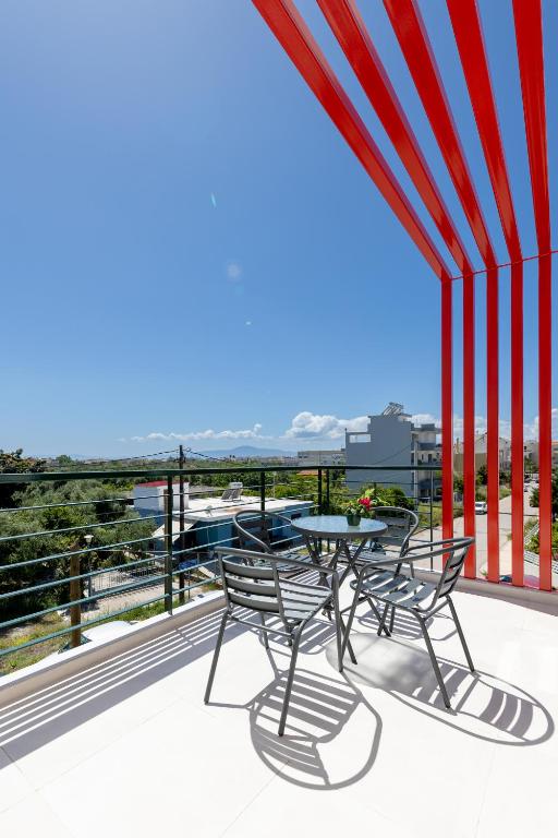 a patio with a table and chairs on a balcony at Pagani Blue - Luxury Maisonette B3 in Kalamata