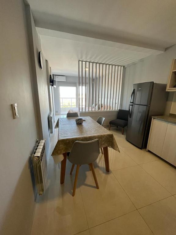 a living room with a table and a kitchen at Departamento Independencia in Neuquén