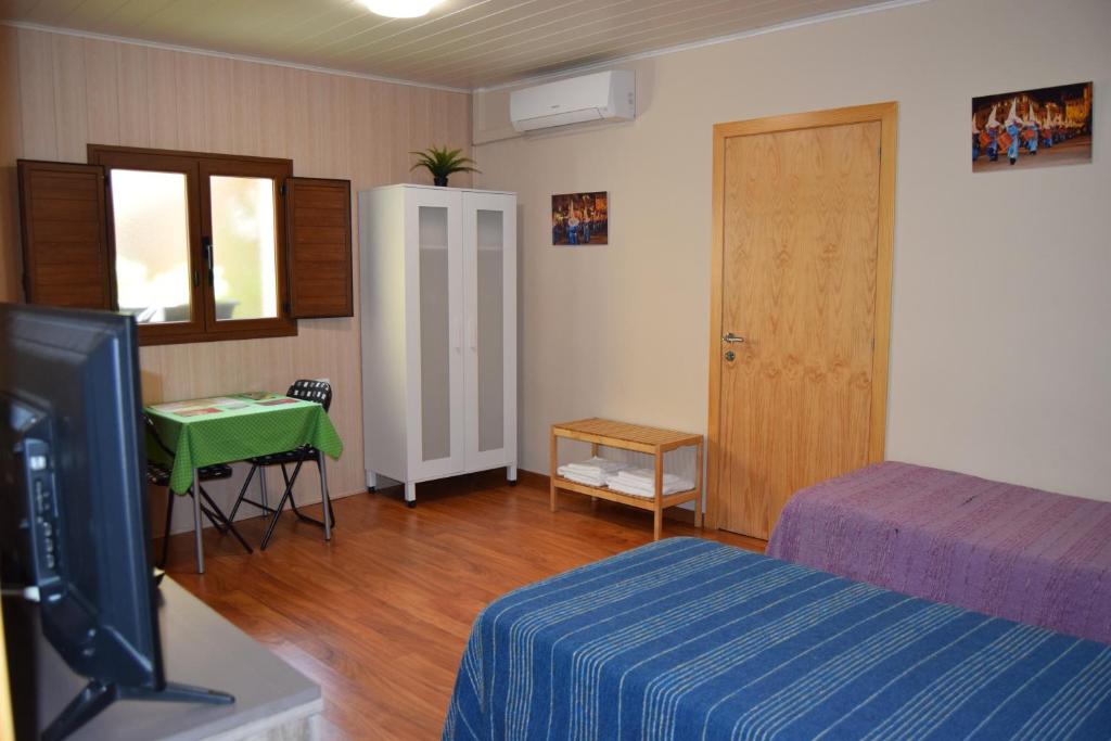 1 dormitorio con cama, mesa y puerta en Habitación independiente II en Casa Rural Javier, en Valmuel