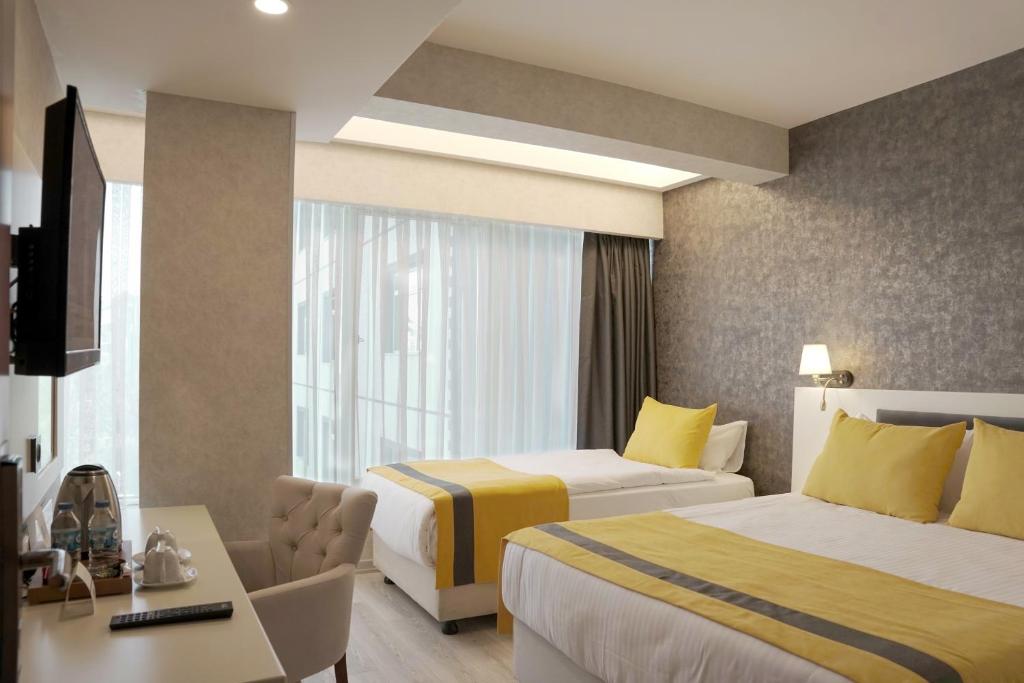 Habitación de hotel con 2 camas y escritorio en Resun Hotel en Ankara