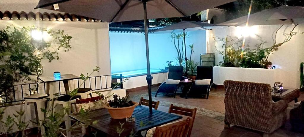 un patio con mesa, sillas y sombrilla en Casa Las Tinajas, en Iznájar