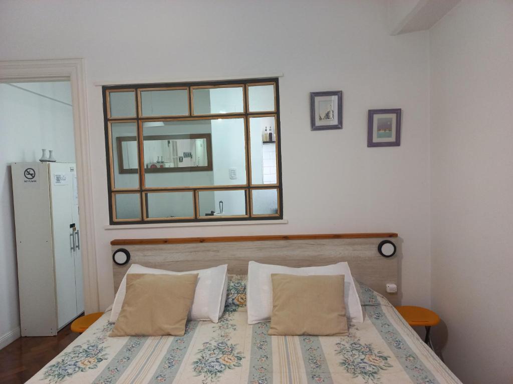 a bedroom with a bed with a mirror on the wall at Acogedor apartamento céntrico. Obelisco. in Buenos Aires