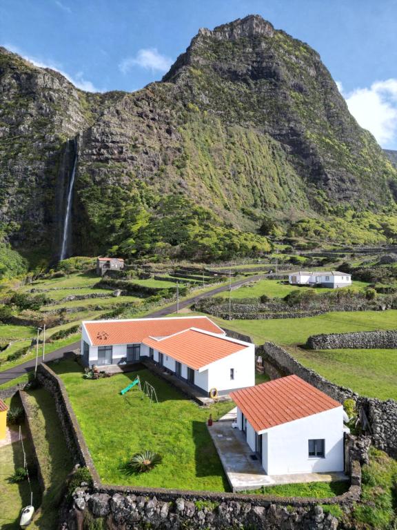 een huis op een heuvel met een waterval op de achtergrond bij Oceanus in Faja Grande