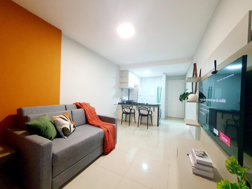uma sala de estar com um sofá e uma televisão em 1 quarto, cheio de estilo, condo club Sky com vaga em Curitiba