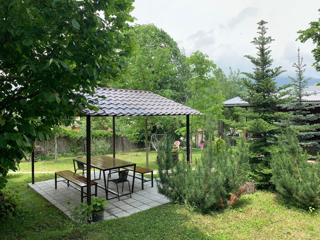 cenador con mesa y bancos en un jardín en TOON 94, en Dilijan