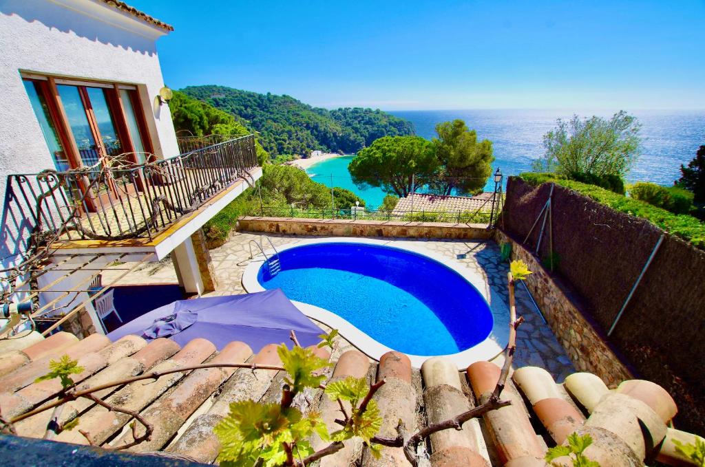 a swimming pool with a view of the ocean at V&V LLORET- VILLA MEDITERRANIA preciosa villa con vistas panorámicas al mar y a solo 120m de la playa Cala Canyelles!! in Lloret de Mar