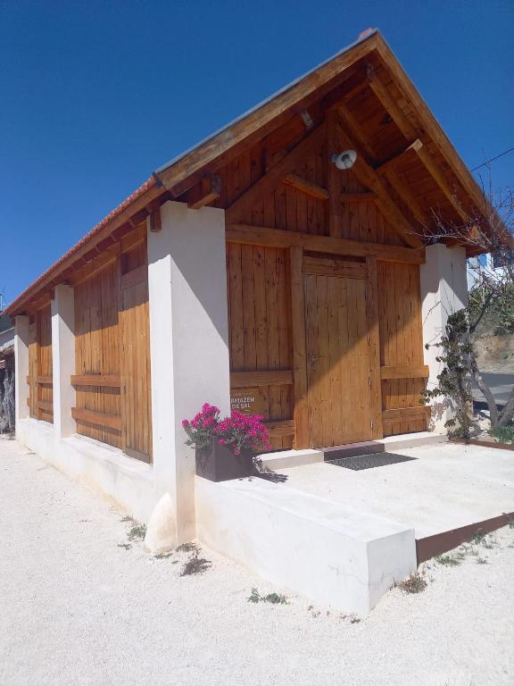 a wooden building with flowers in front of it at Armazém de Sal - Alojamento Loft in Rio Maior