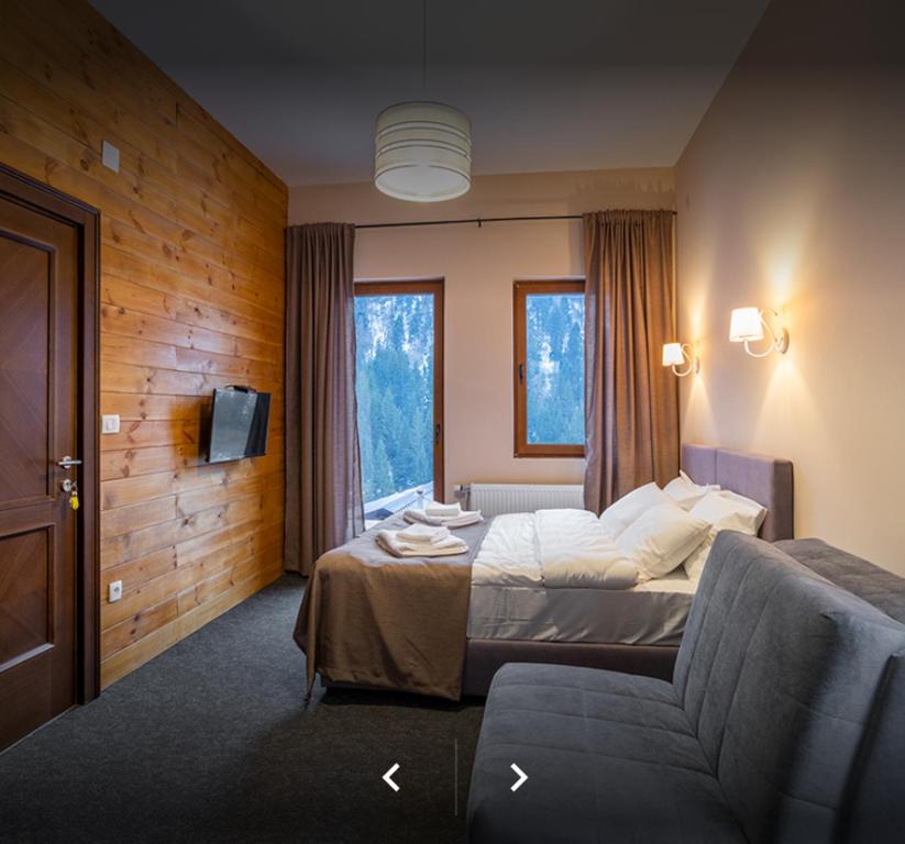 a hotel room with a bed and a couch at Keystone Villas in Kolašin
