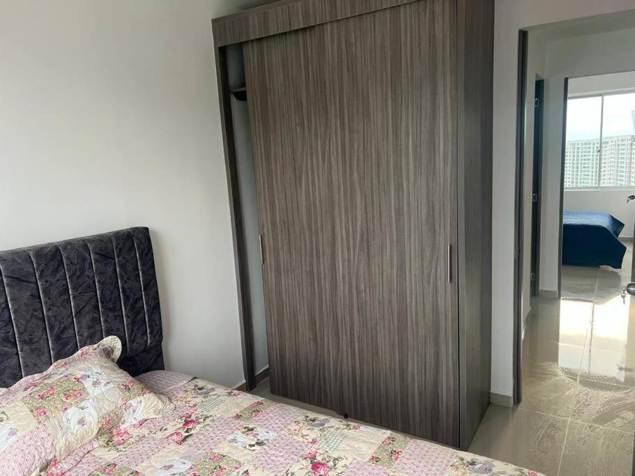 a bedroom with a bed and a wooden closet at Confortable apto en Armenia 1505 in Armenia