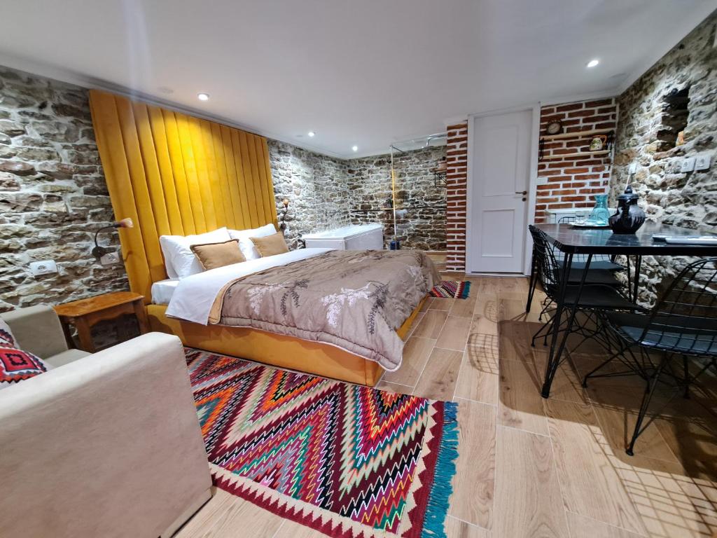 um quarto com uma cama e uma mesa num quarto em "Villa 70" Guesthouse em Gjirokastër