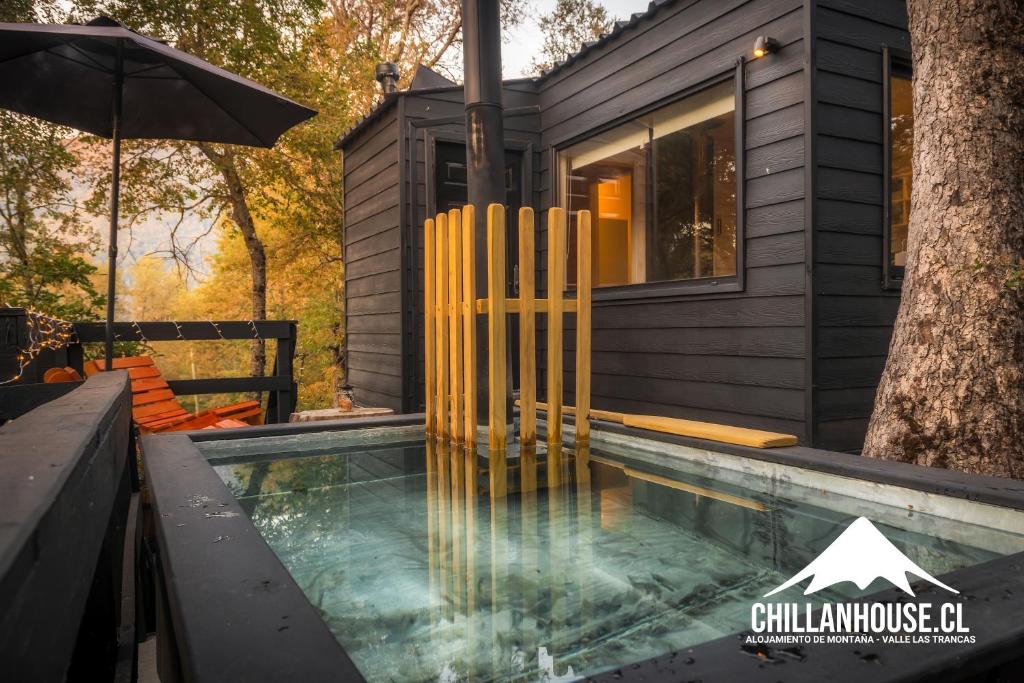 a house with a swimming pool and an umbrella at Chillán House in Las Trancas