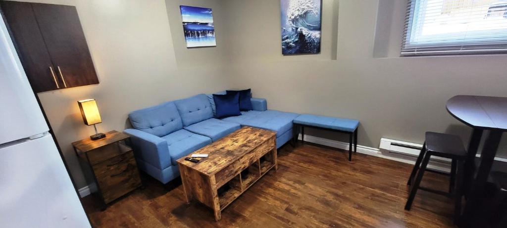 a living room with a blue couch and a table at Blue Wave 2 bedroom suite in Saskatoon
