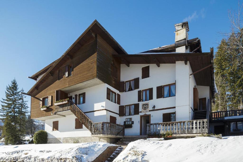 un edificio con nieve delante en Villa Casanova - Stayincortina, en Cortina dʼAmpezzo