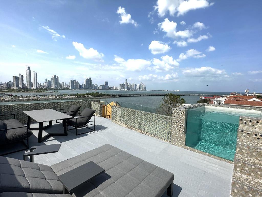 a patio with a table and chairs and a swimming pool at AmazINN Places Penthouse Deluxe, Skyline and Private Rooftop in Panama City