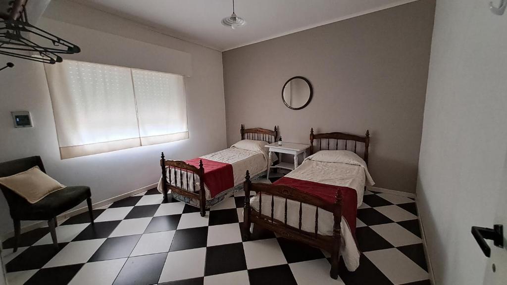 2 Betten in einem Zimmer mit kariertem Boden in der Unterkunft Brasil.gchu in Gualeguaychú