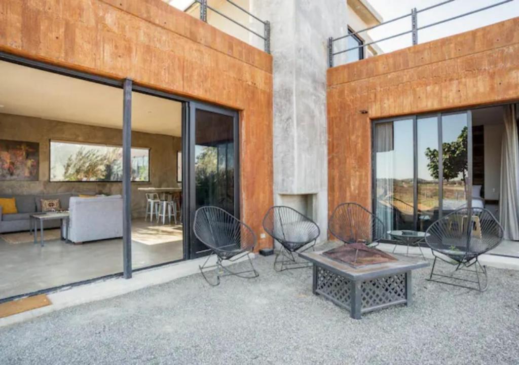 a patio with chairs and a table in a building at Chateaux del Valle Vacational Homes in Valle de Guadalupe