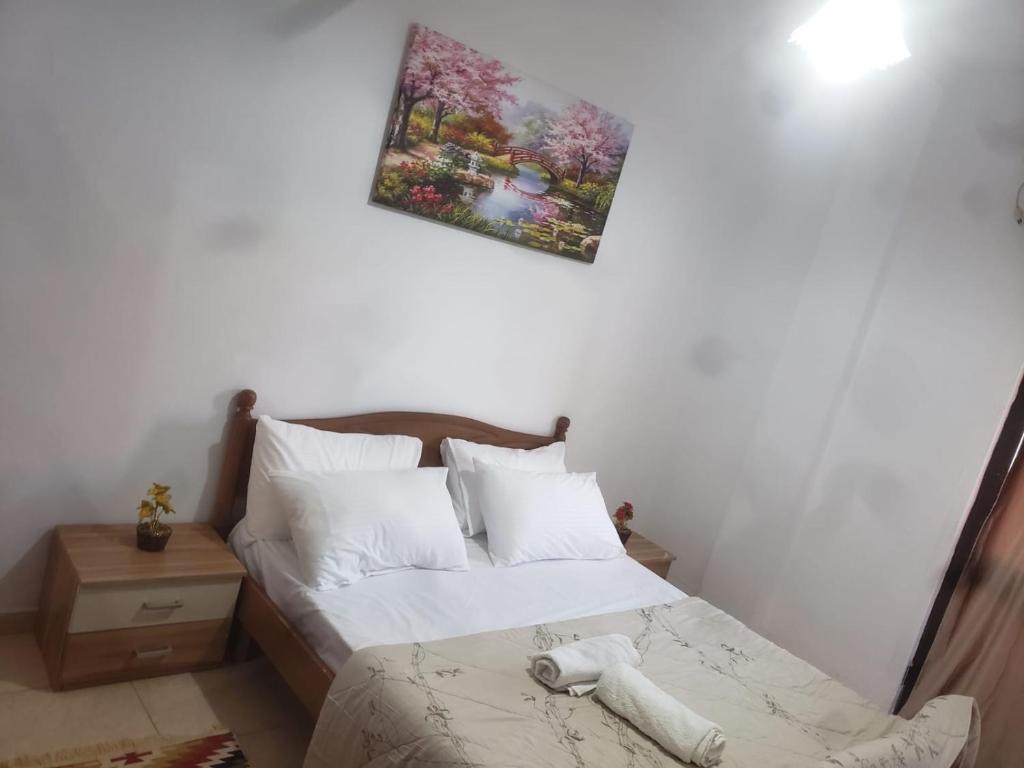 ein Schlafzimmer mit einem Bett und einem Bild an der Wand in der Unterkunft Hostel Split Rock in Tirana