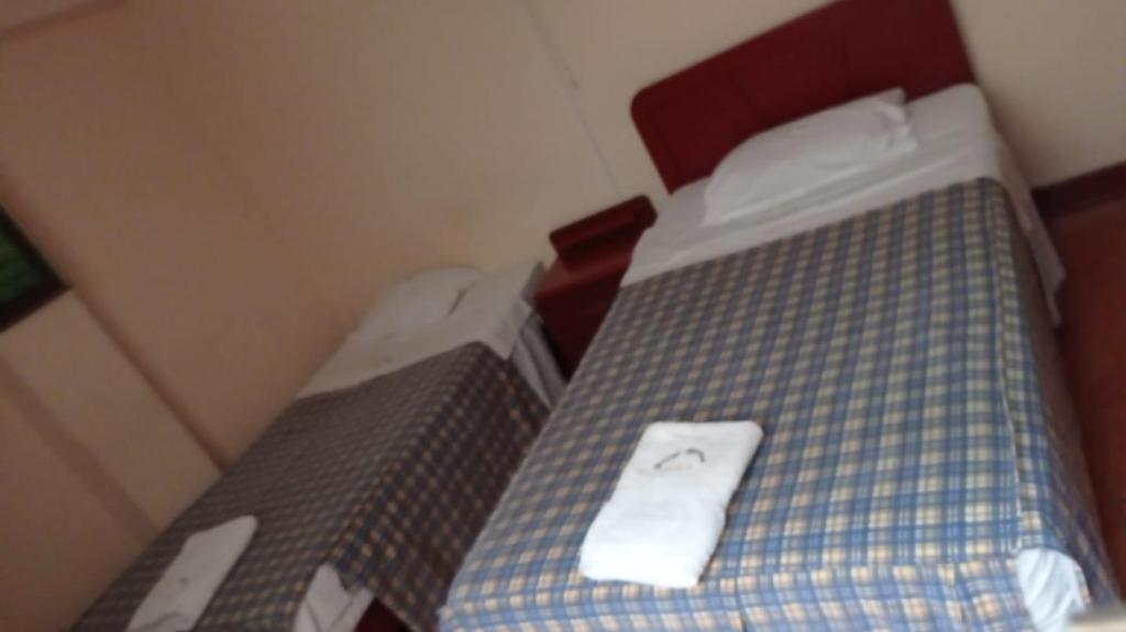 Un pequeño dormitorio con una cama con una toalla. en Hotel Aquarius, en Chimbote