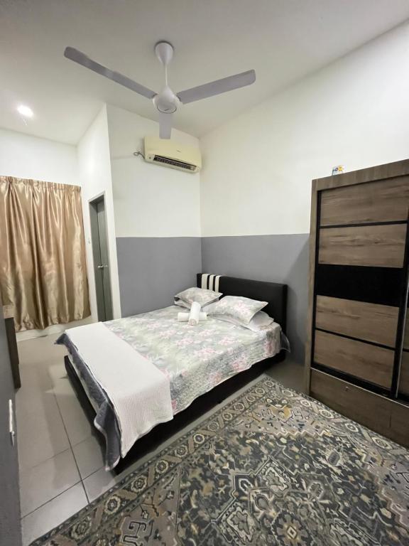 a bedroom with a bed and a ceiling fan at DRest Homestay Desa Aman 