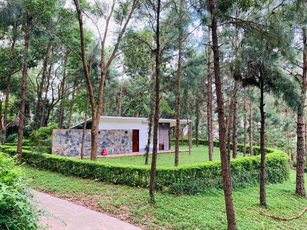 una casa en medio de un parque con árboles en Hilltop Flamingo Đại Lải H230 Villa, en Hanói