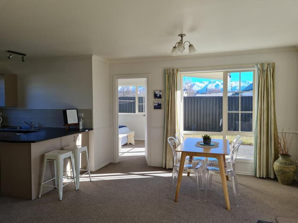 a kitchen and dining room with a table and chairs at Relax on Rata, Cottage 1 in Twizel