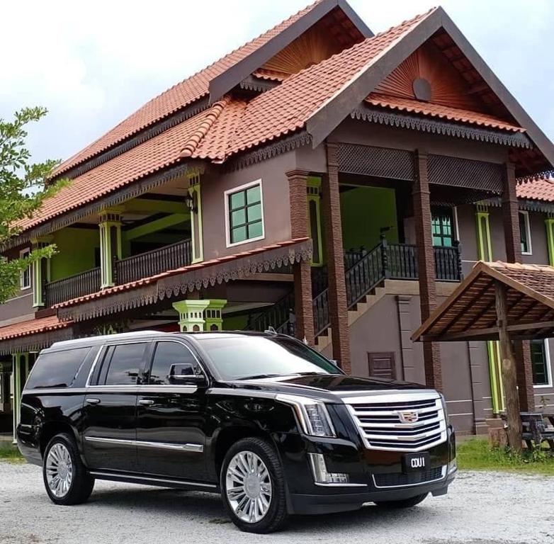 a black limousine parked in front of a house at RAZAK GUEST HOUSE in Setiu