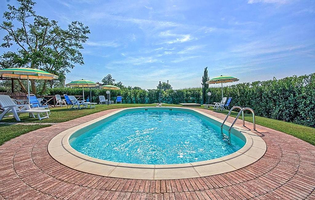 einen Pool im Garten mit Stühlen und Sonnenschirmen in der Unterkunft Lovely Home In Marsiliana With Private Swimming Pool, Can Be Inside Or Outside in Marsiliana