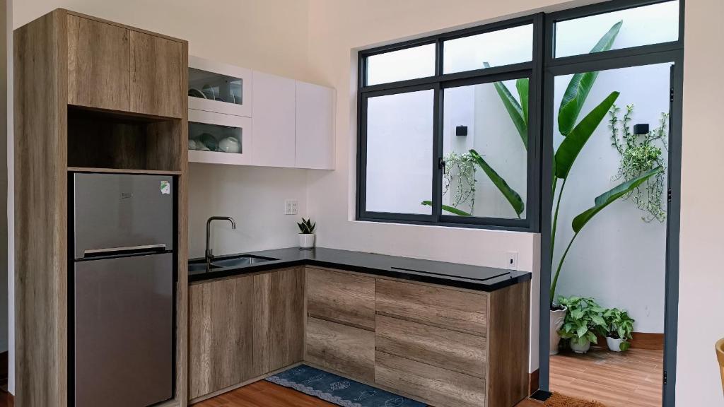 eine Küche mit einem Kühlschrank und einem Fenster in der Unterkunft Khanh Thy Homestay Lagi in La Gi