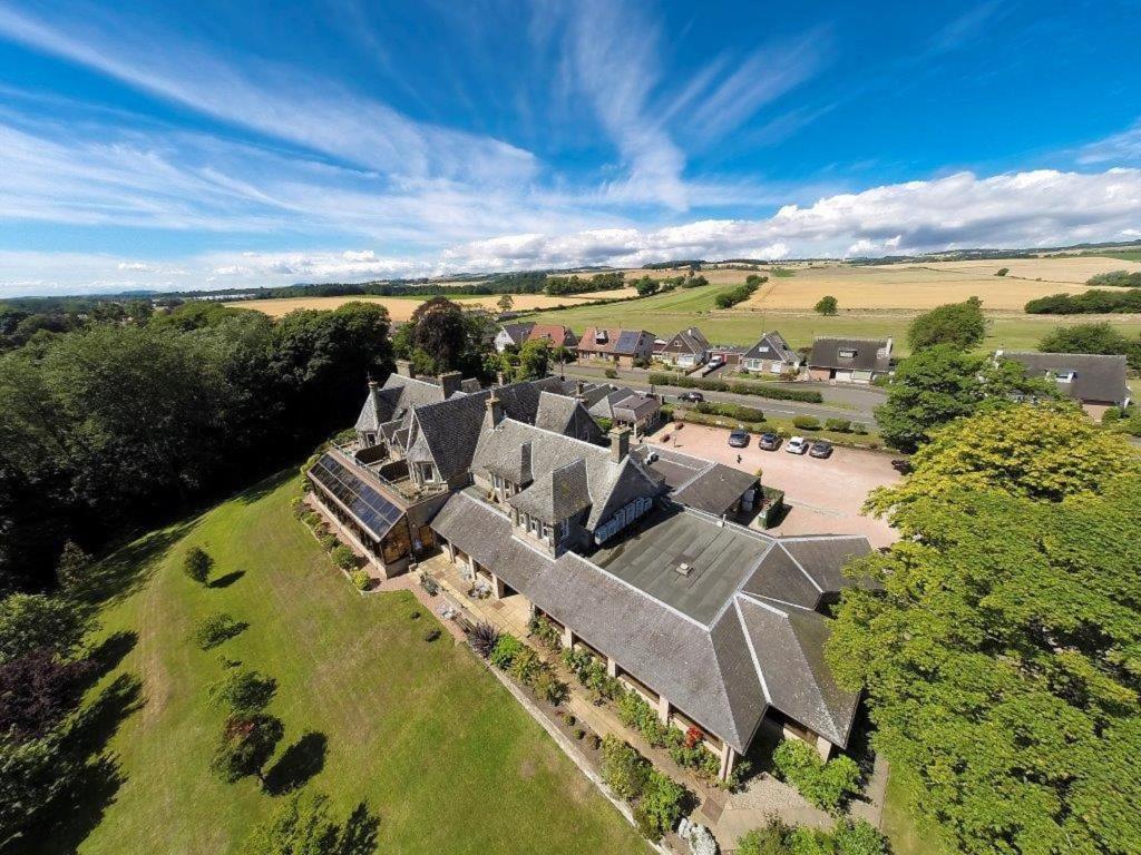 - une vue aérienne sur un grand domaine avec une grande maison dans l'établissement Old Manor Hotel, à Lundin Links