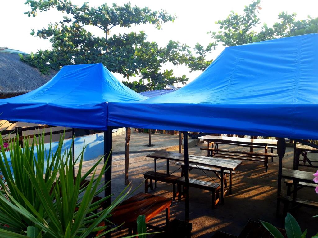 a blue tarp over picnic tables and a pool at CRISTINA Beachfront Cottages in San Juan