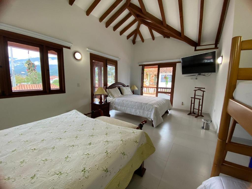 1 dormitorio con 2 camas y TV de pantalla plana en CASA BELLA, en Villa de Leyva