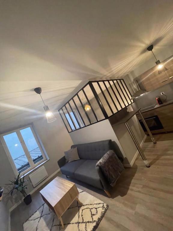 un salon avec un canapé et un escalier dans l'établissement Cocon Cosy Nancy centre, à Nancy