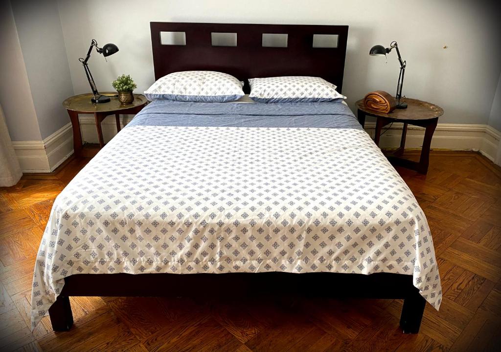 a bedroom with a large bed with two side tables at Spacious Bedroom in a Brooklyn House Shared with Host in Brooklyn